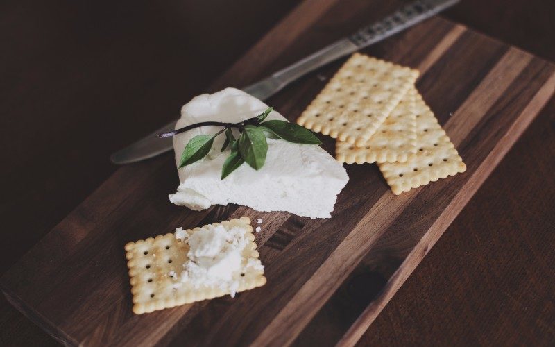 cheese and crackers on a wooden board
