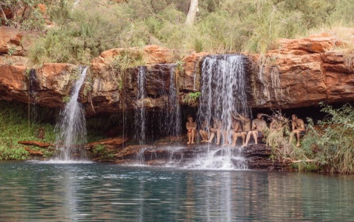 Travellers under a waterfall in Karinjini National Park