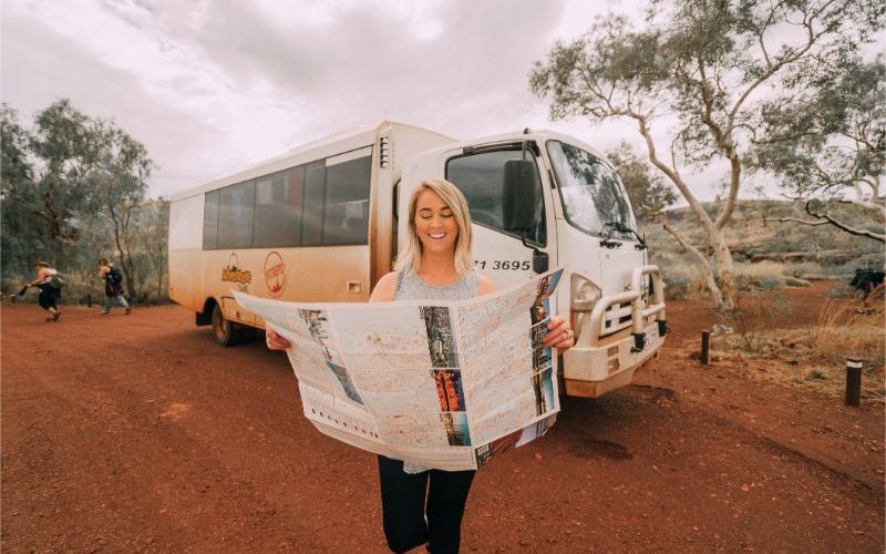 Person holding a map in front of a truck in the outback